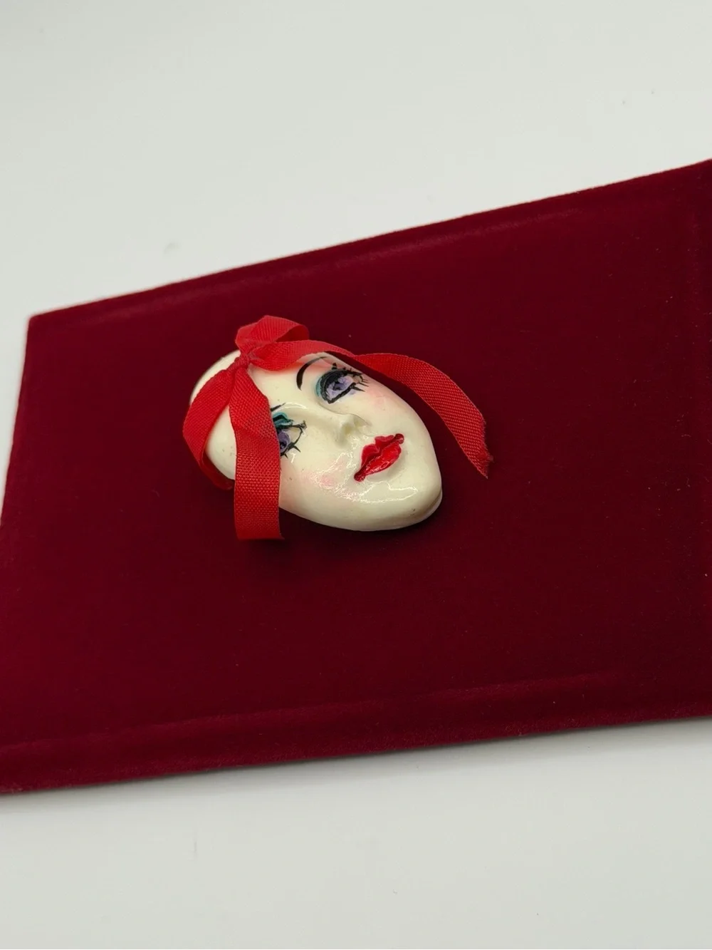 Vintage Face Brooch with Red Ribbon Accent